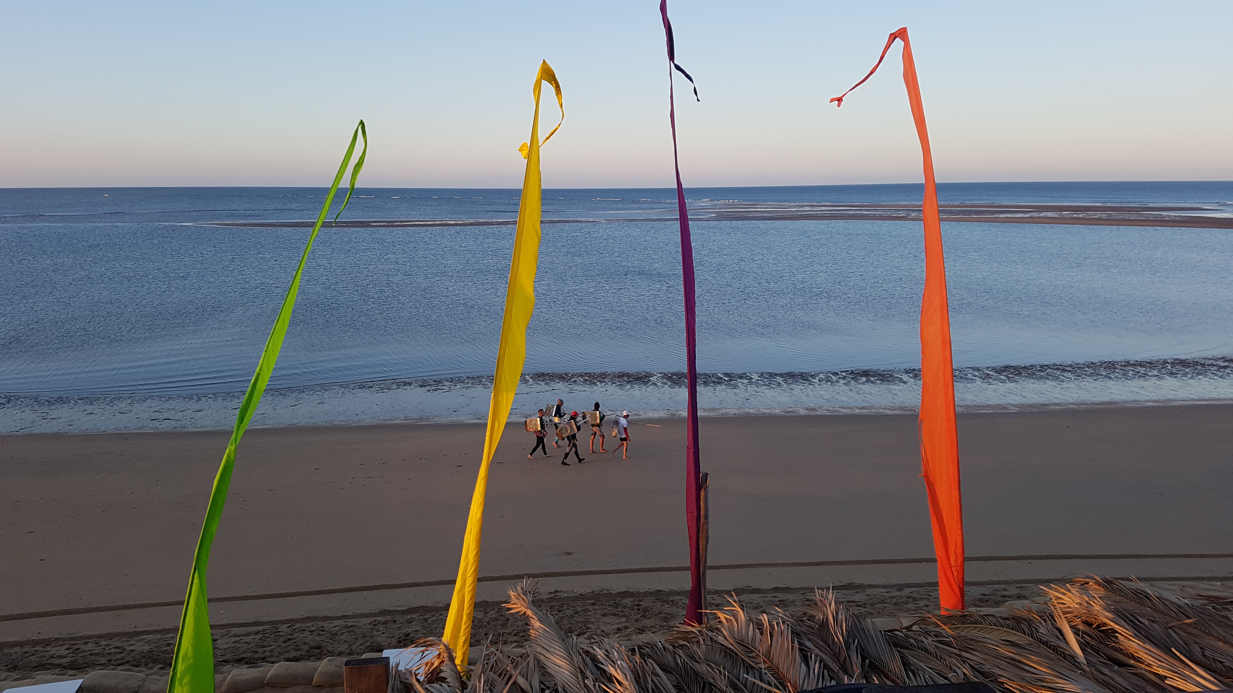 Banderas de colores frente al mar al atardecer